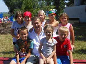 Pastor Savich with children at camp